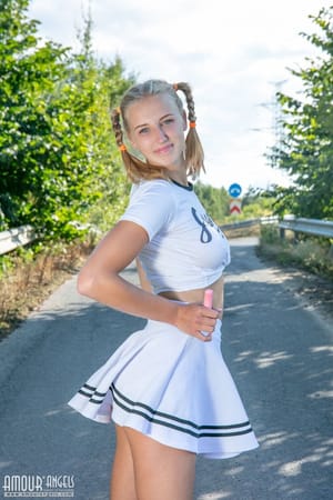Nana szőke pomponlány vetkőzik egy aszfaltozott úton